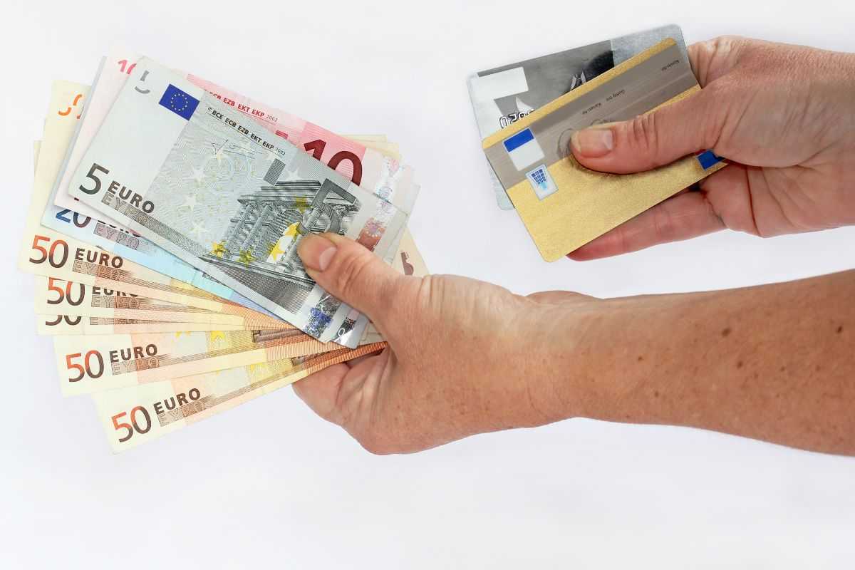 persona con soldi e carte in mano