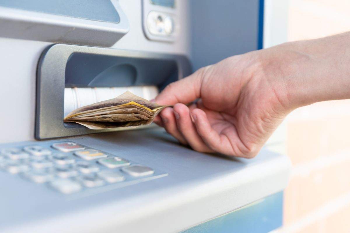 persona che preleva dei soldi al bancomat